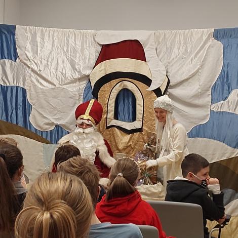 Mikołaj wraz z bohaterka przedstawienia wręczają prezenty