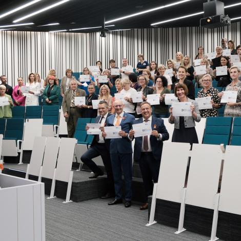 Uczestnicy spotkania z kartkami z hasłem konferencji.